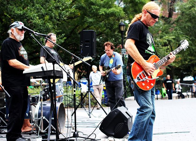 People look on as a political band performs in Union Square in the late afternoon.